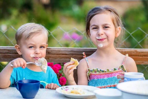 Funny boy and girl eating dumplings and making a mess