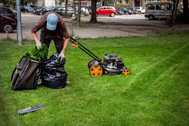 Çim biçme. Bahçıvan çim ile bir elektrik biçme mows. Bahçe, bahar temizliği işe. Bahçe ve çim bakımı.