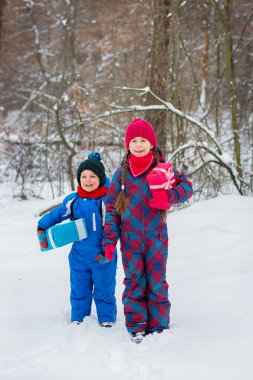 Mutlu çocuk hediye kutuları ile bir kış karla kaplı ormanda. Noel ve yeni yıl için Noel eğlenceli.