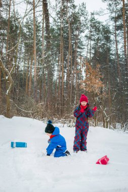 Mutlu çocuk hediye kutuları ile bir kış karla kaplı ormanda. Noel ve yeni yıl için Noel eğlenceli.