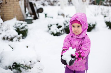 Bir çocuk kartopu açık havada bir kış gününde sculpts. Kış oyunları.