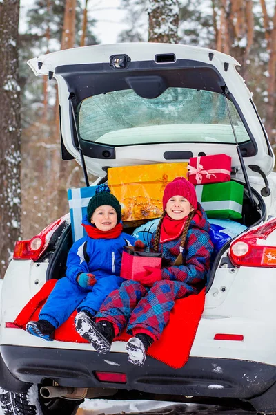 うれしそうな子供たちは 車のトランクに多くのクリスマス プレゼントをお楽しみください 寒い冬 雪の天気 — ストック写真
