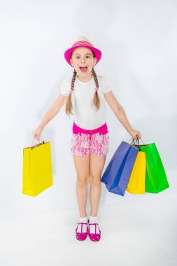 Satılık. Sevimli kız beyaz bir arka plan üzerinde çanta dolu. Alışveriş üzerinde bir çocuk portresi.