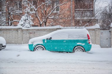Araç park yerinde bir kış kar fırtınası kar kaplı. Karla kaplı yollar ve şehrin sokaklarında.