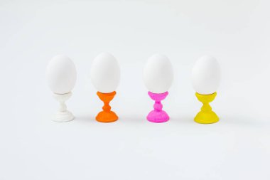 Beyaz haşlanmış yumurta beyaz arka plan ile ahşap ayakları üzerinde. Paskalya tatili hazırlık.