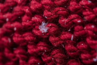 Kırmızı bir closeup ekose üzerine kaç kar taneleri ile ördü. Makro çekim.