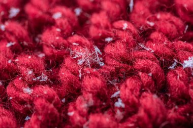 Kırmızı bir closeup ekose üzerine kaç kar taneleri ile ördü. Makro çekim.