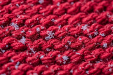 Kırmızı bir closeup ekose üzerine kaç kar taneleri ile ördü. Makro çekim.