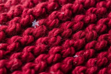 Kırmızı bir closeup ekose üzerine kaç kar taneleri ile ördü. Makro çekim.