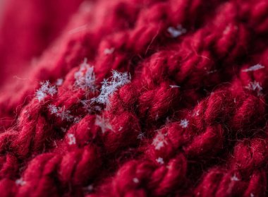 Kırmızı bir closeup ekose üzerine kaç kar taneleri ile ördü. Makro çekim.