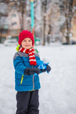 Kartopu parkta yapmak mutlu çocuk kar karlı kış yürüyüş ile oynarken. Kış açık hava oyunları.