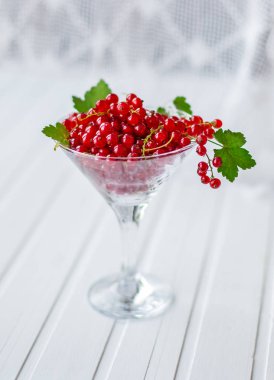 Mutfak ahşap bir masa üzerinde bir cam kabı içinde taze kırmızı kuş üzümü. Berry tatlı, meyve suyu, reçel hazırlık koruma.