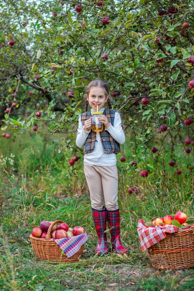 Portrait of a cute girl in a farm garden with a red apple. — Stock Photo, Image