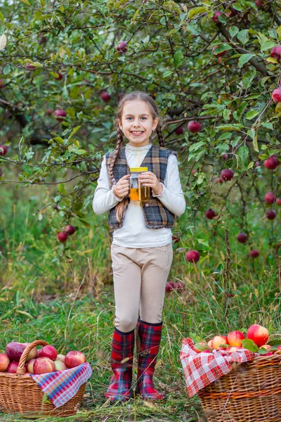 Portrait of a cute girl in a farm garden with a red apple. — Stock Photo, Image