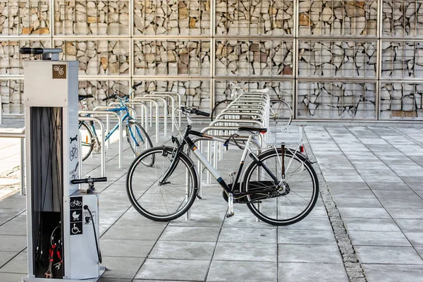 Parkerings plats för cyklar. Cykel på parkeringen, mycket tomma säten. Cykeln är kedjad på cykel hållaren. — Stockfoto