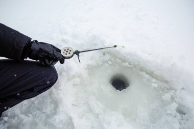 Oltayla bir ricky balıkçısı yakın. Kış balıkçılık için buz ve olta. Kış balıkçılığı. Küçük balık avı.