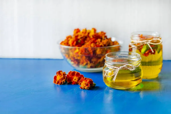 Processing of dried flowers marigolds. Bottle of Chornobrivtsi essential oil . — Stock Photo, Image