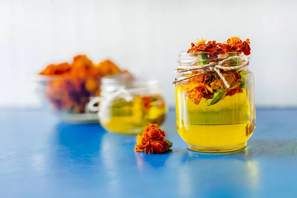 Processing of dried flowers marigolds. Bottle of Chornobrivtsi essential oil . — Stock Photo, Image