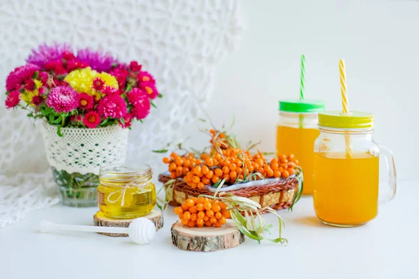 White background, natural lighting. Warm sweet organic tea with sea buckthorn berries, thyme and honey.