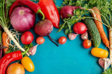 Mavi arka planda çiğ sebzeli kompozisyon. Sebze çerçevesi.
