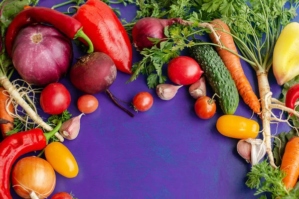 Skład z surowych warzyw na fioletowym tle. Rama warzyw. — Zdjęcie stockowe