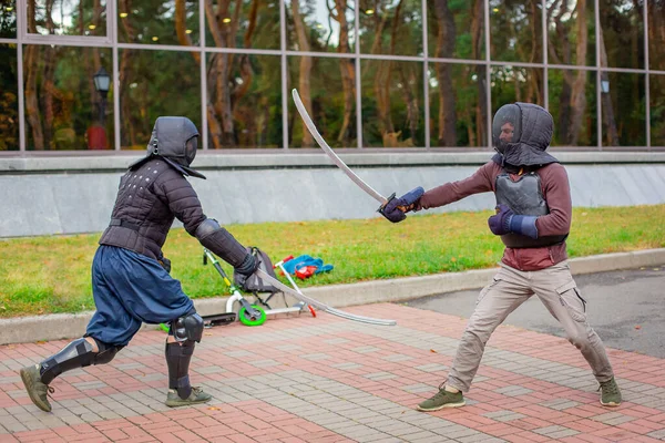 Dva ozbrojení muži vedou souboj s mečem, středověký souboj, na zábavném středověkém turnaji. Sportovní soutěže. — Stock fotografie