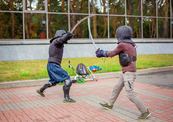 Dva ozbrojení muži vedou souboj s mečem, středověký souboj, na zábavném středověkém turnaji. Sportovní soutěže. — Stock fotografie