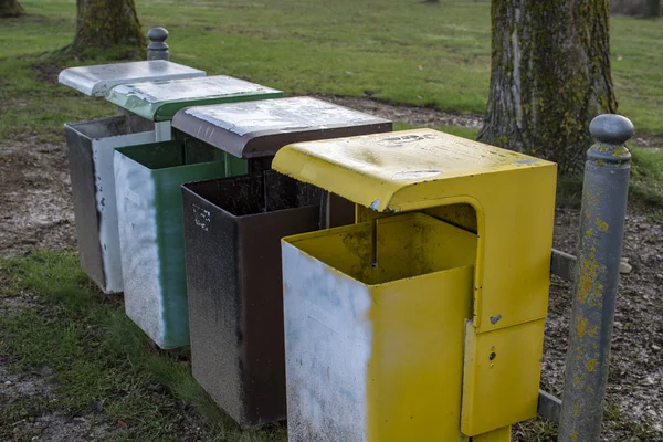 在草地上与四个不同颜色的垃圾桶的废物分离 — 图库照片
