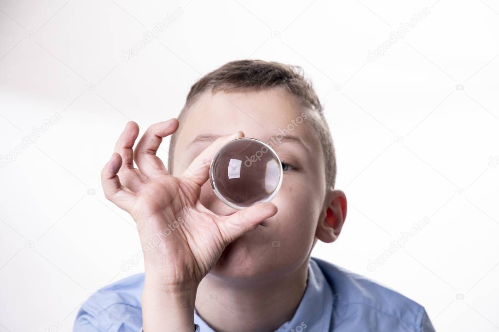 Boy looks dreamily into a glass ball to predict the future