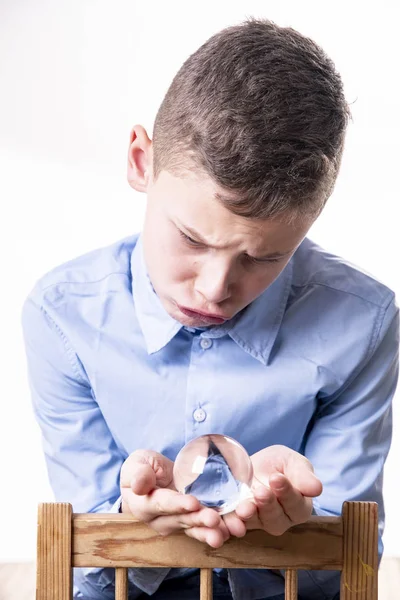 Αγόρι Είναι Πολύ Θλιμμένο Και Κοιτάζει Μια Γυάλινη Μπάλα Χέρια — Φωτογραφία Αρχείου