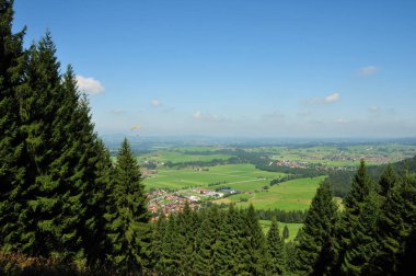 Yamaçparaşütü mavi gökyüzü ile güzel bir vadi üzerinde kayma turuncu bir şemsiye ile