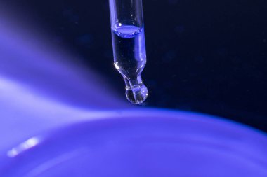 Sıvı ile mavi su üzerinde pipet