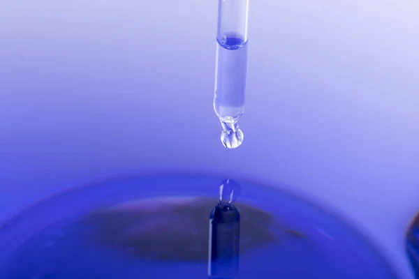 Pipette Mit Flüssigkeit Über Blauem Wasser — Stockfoto