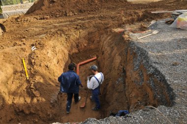 bir inşaat iki esnaf bir boru kontrol sistemi üzerinde çalışmaya çukur