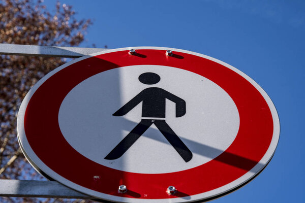 Знак "Никаких пешеходов" против голубого неба
