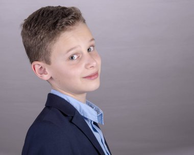 güzel oğlan mavi gömlek ve ceket yana kameraya doğru görünüyor