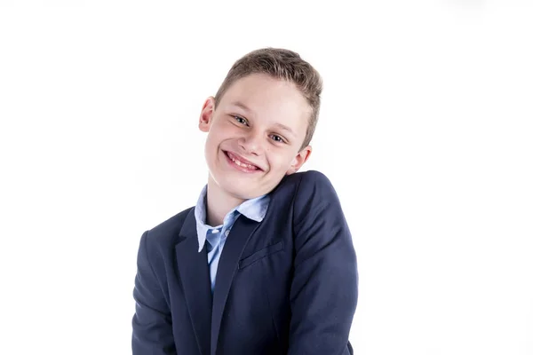 Menino com uma camisa azul e um casaco sorri amigável para a câmera — Fotografia de Stock