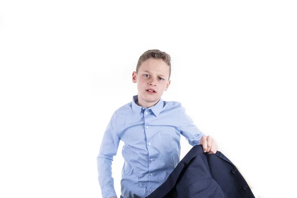 Chic dressed boy in a blue shirt looks directly into the camera and takes off his jacket — Stock Photo, Image