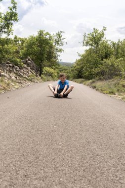 Oğlum oturur yan tarafından uzun bir yolda tek başına yalnız ağaçlar büyümek