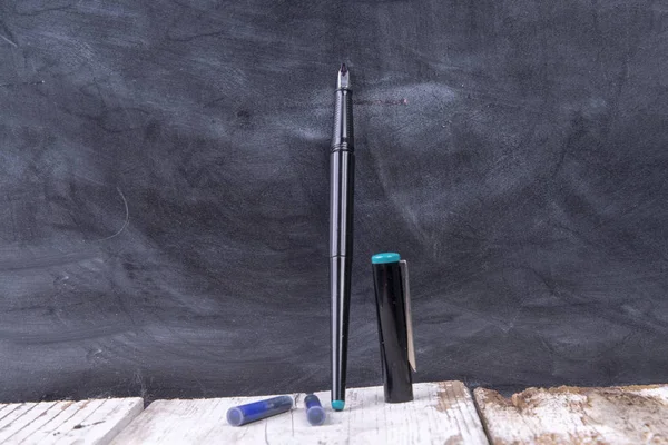 Фонтанная ручка с чернильными картриджами, открытыми крышкой и доской — стоковое фото