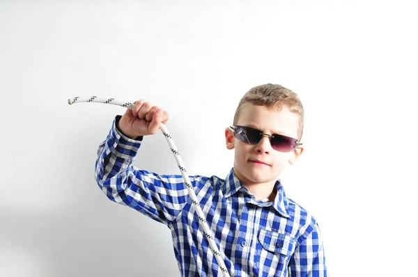Хлопчик з сонцезахисними окулярами і перевіреною сорочкою, що тримає мотузку в руках — стокове фото