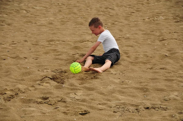 노란 공을 가진 해변에서 노는 소년 — 스톡 사진