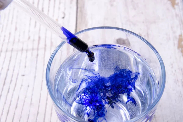 Blue ink dropping in a glass of water — Stock Photo, Image