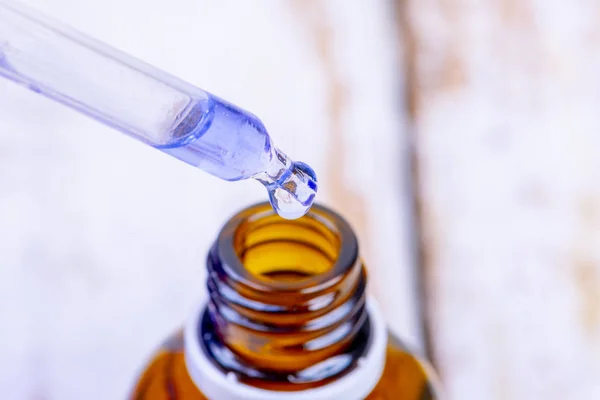 Mavi mürekkeple pipet ve kahverengi cam ilaç şişesi — Stok fotoğraf