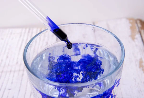 Cam içinde pipet içeren bir laboratuvarda mavi sıvı — Stok fotoğraf
