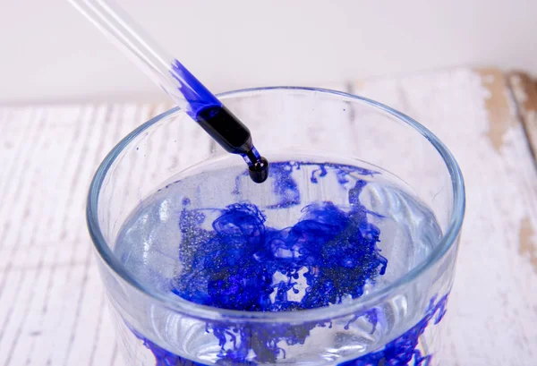cam içinde pipet içeren bir laboratuvarda mavi sıvı
