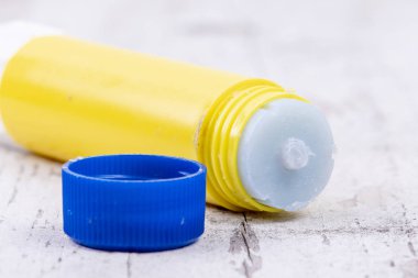 rustik beyaz ahşap üzerinde mavi kapak ile sarı tutkal sopa