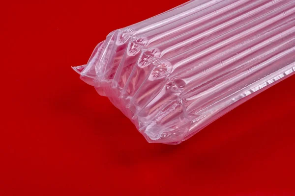 Műanyag csomagolás légpárnával, vörös alapon — Stock Fotó