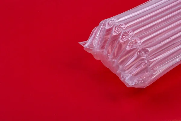 Plastové obaly se vzduchovou polštáři na červeném pozadí — Stock fotografie