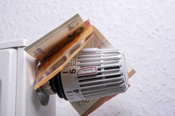 Thermostaat op een radiator met bankbiljetten-Bespaar verwarmingskosten — Stockfoto